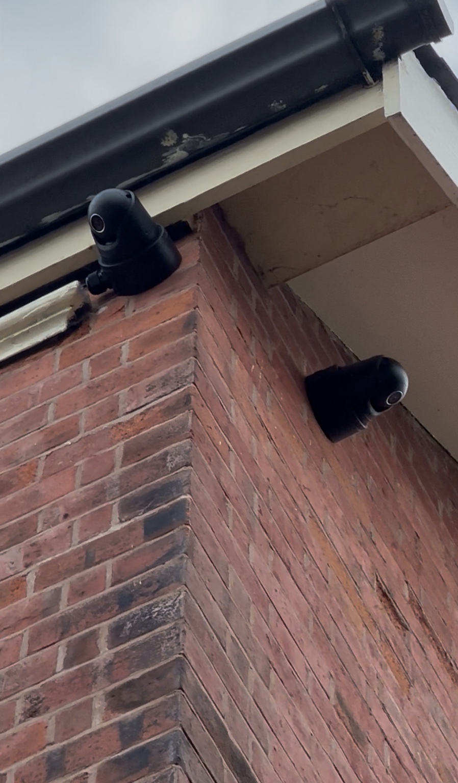 Two black external CCTV cameras installed on a Chesterfield home